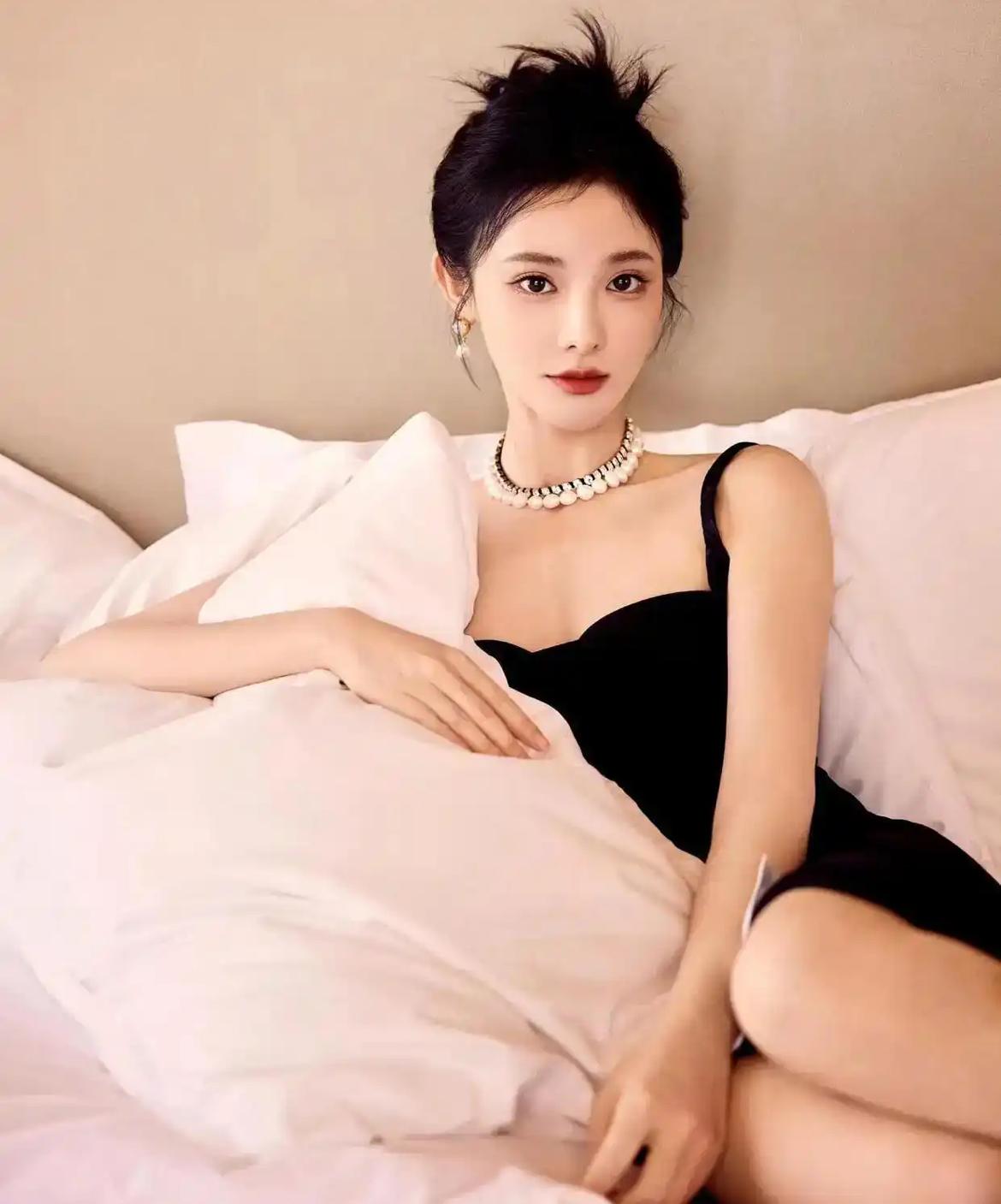 这位女士躺在床上，穿着黑色连衣裙，戴着珍珠项链。你认为人幸福不幸福取决于什么