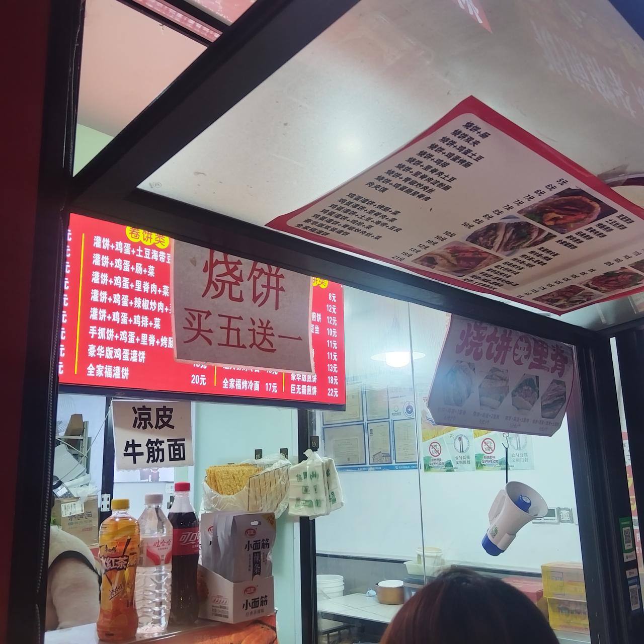 家旁边一个卖煎饼、炒冷面、烧饼夹肉等小吃的小门脸，傍晚的生意特别好。老板娘一个人