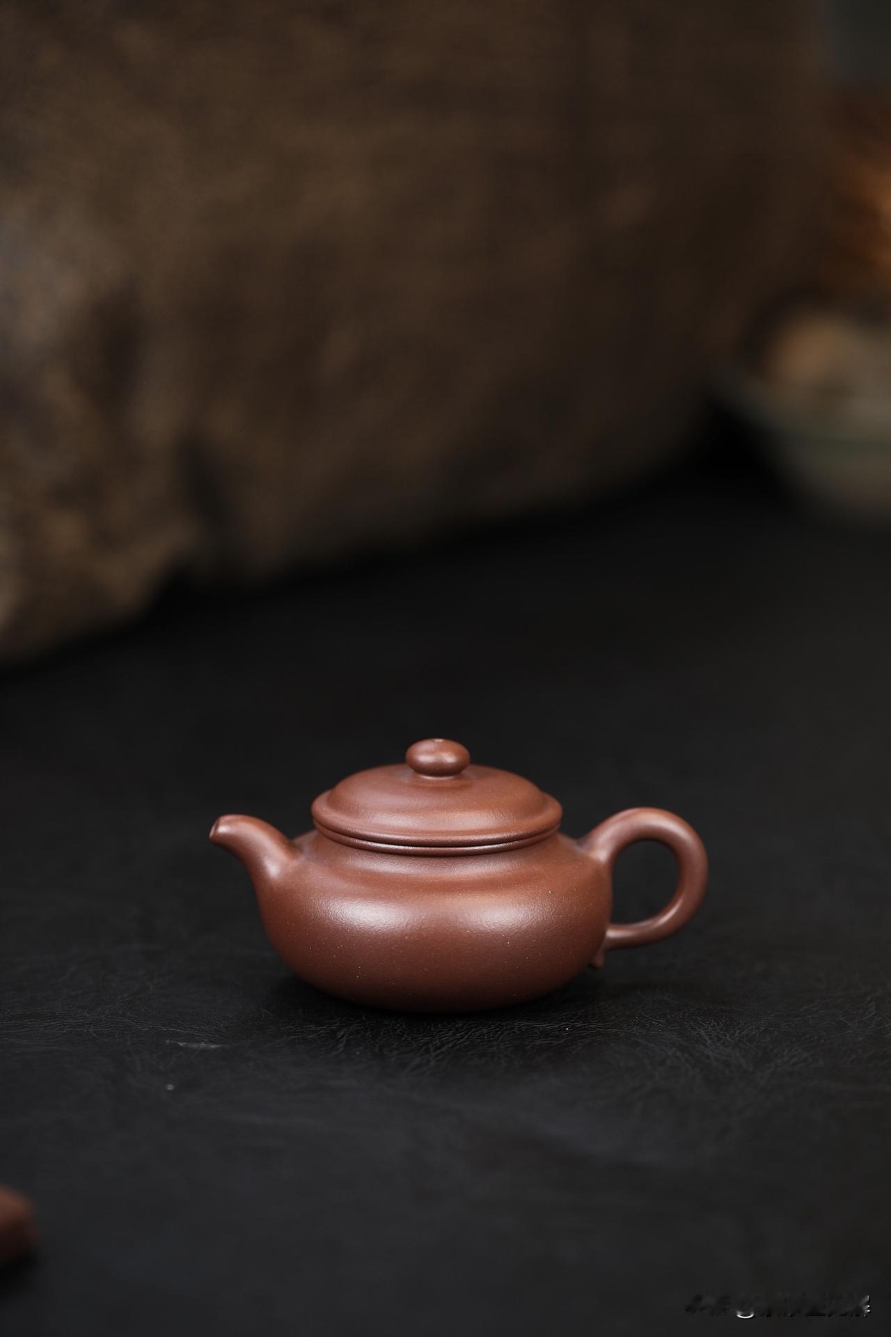 一把壶的“人味儿”
朋友从宜兴带回一把紫砂壶，褐中透赤，粗看像个沉默的土疙瘩。他