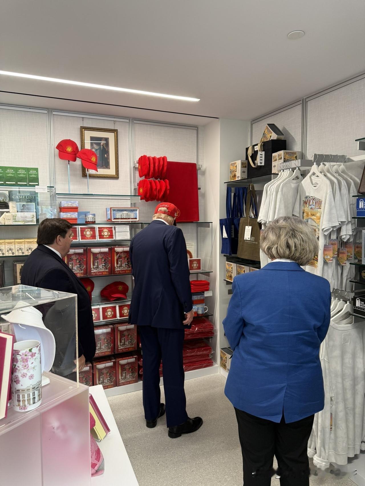 特朗普今天上午带领着自己的内阁成员到白宫对面儿的礼品店买一些东西。礼品店挂满了他