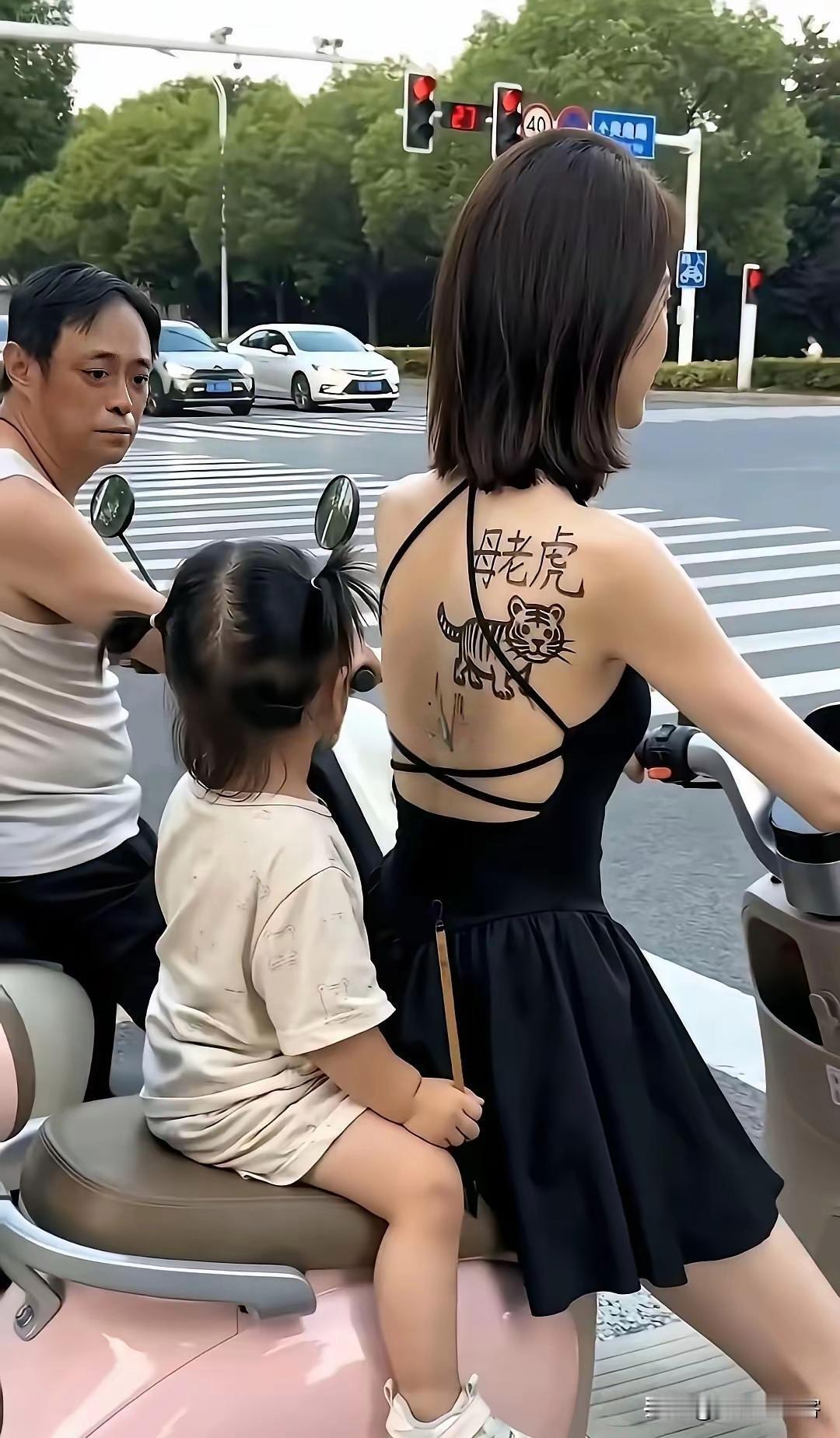 路口等红灯时的一幕画面，不仅让人会心一笑。电瓶车后座，小姑娘握着小画笔，在妈妈后
