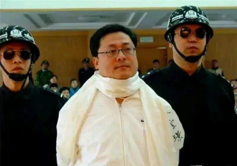 2006年，袁宝璟即将被押送刑场前一张罕见的留影，镜头中的他戴着眼镜，围着一条乳