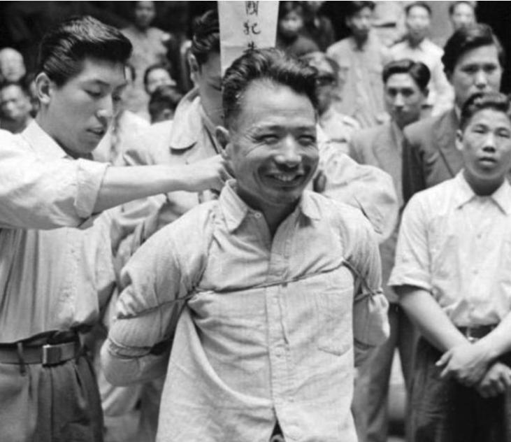面带笑容、从容赴死——照片中这位梳着背头，反剪双手，背插亡命旗牌的人叫朱大同。他