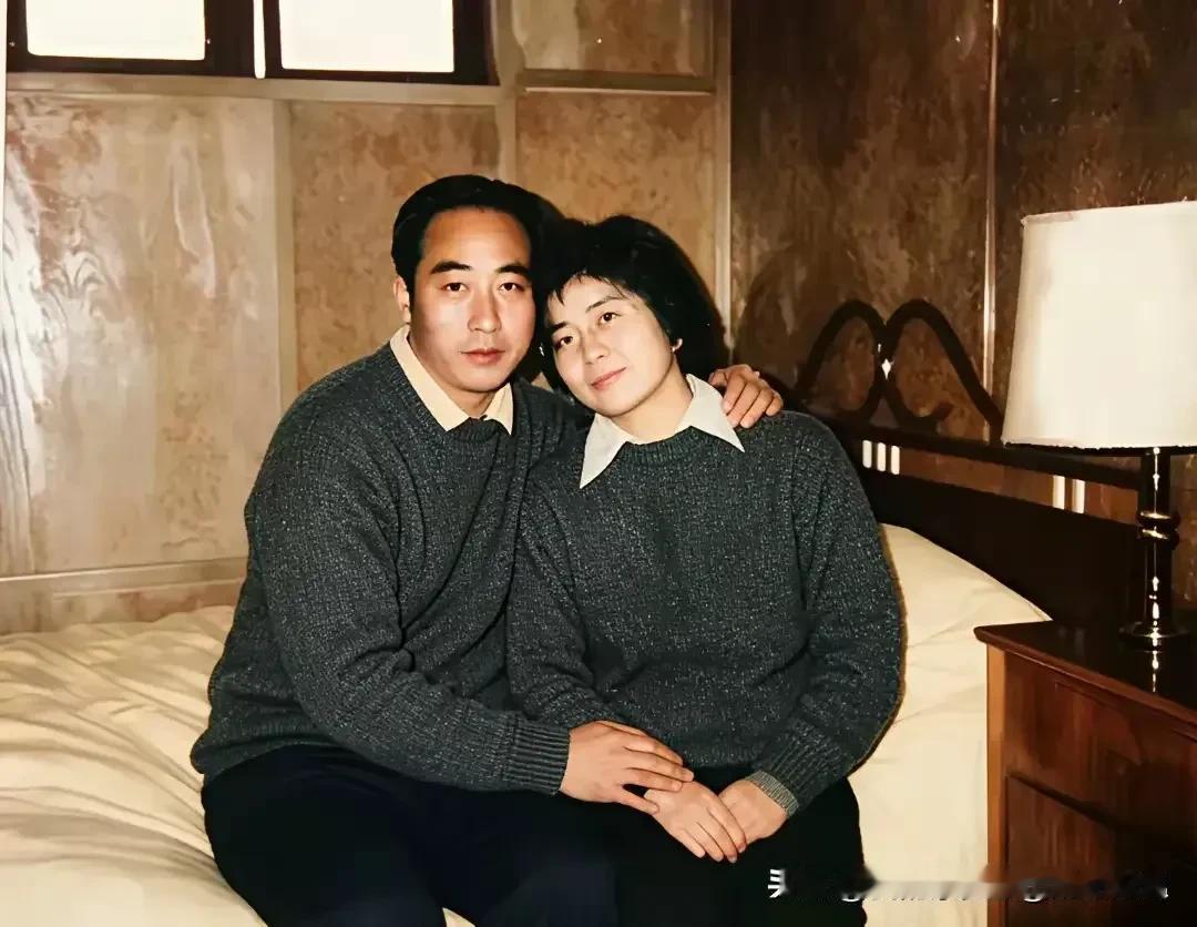 照片里，庄则栋和妻子佐佐木敦子并肩坐在床沿，穿着同款灰色毛衣，手臂轻轻搭在妻子肩