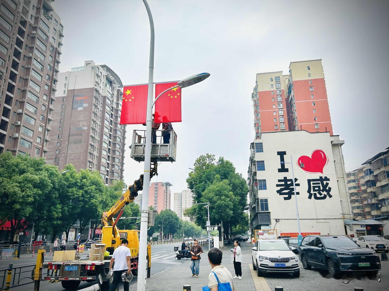 街头飘着艳红的国旗（随手拍）。国庆将至，孝感街头的节日氛围已然漫开。今早途经孝感