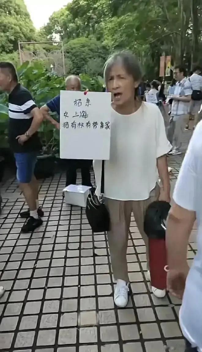 上海某公园相亲角，一位本地阿姨举牌为女择婿：“女，上海，招有权有势的亲家。”阿姨