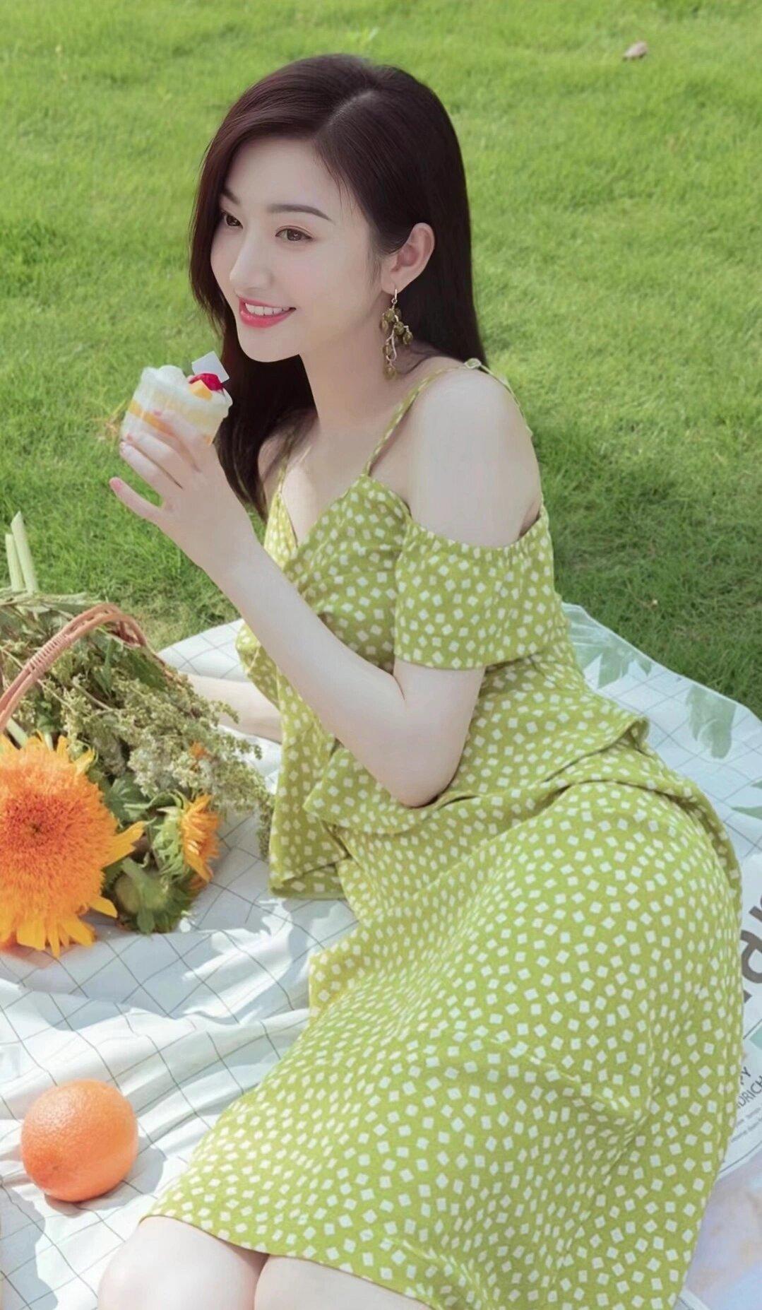 景甜穿着一件绿色的波点连衣裙，搭配白色的荷叶边上衣，展现出了清新可爱的气质。

