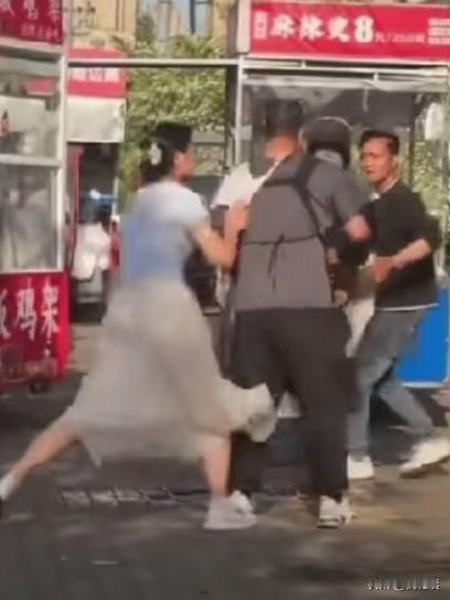大街上两家摊主发生争执，一年青女子青，竟然苗众把内裤脱下来，套在对方的头上！
