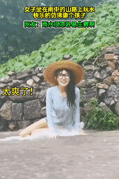 女子坐在雨中的山路上玩水，快乐的仿佛像个孩子！[大笑]