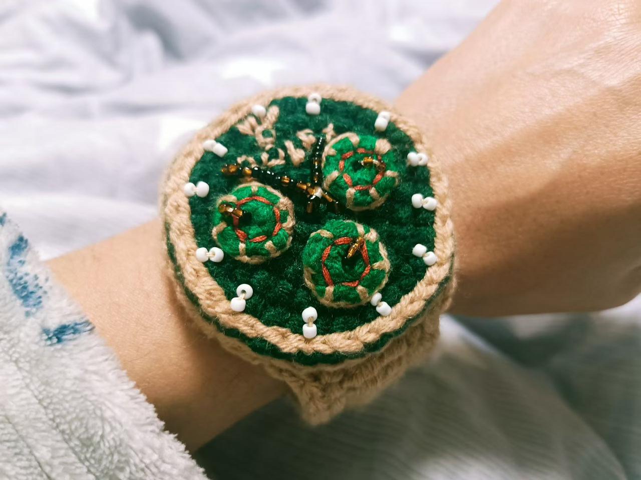 手工编织的绿色发圈，点缀着可爱的小花和珍珠，清新自然，适合日常穿搭。