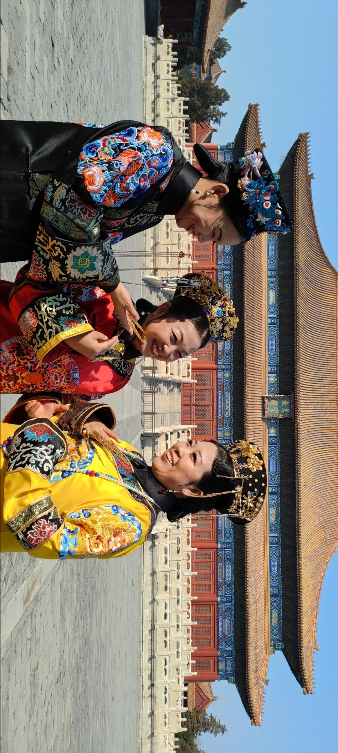 故宫前，两位古装美女笑语盈盈，传统服饰尽显古典韵味。