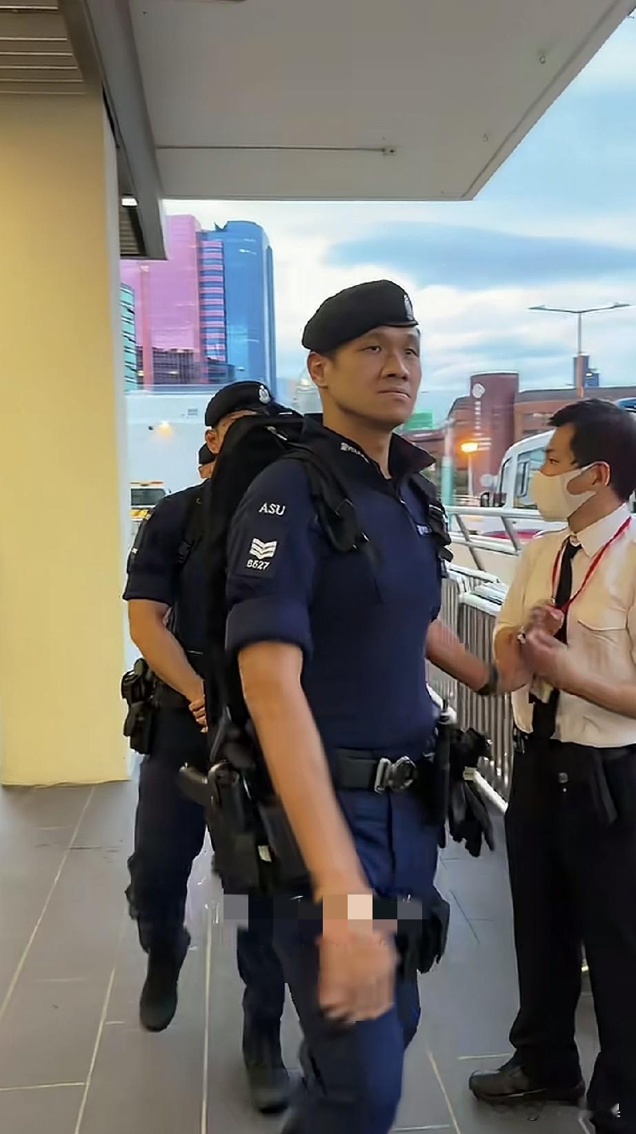 好帅气的港警，不知道这个包里背的是什么？这个包看着很特别，扁扁的、但是很细很长。