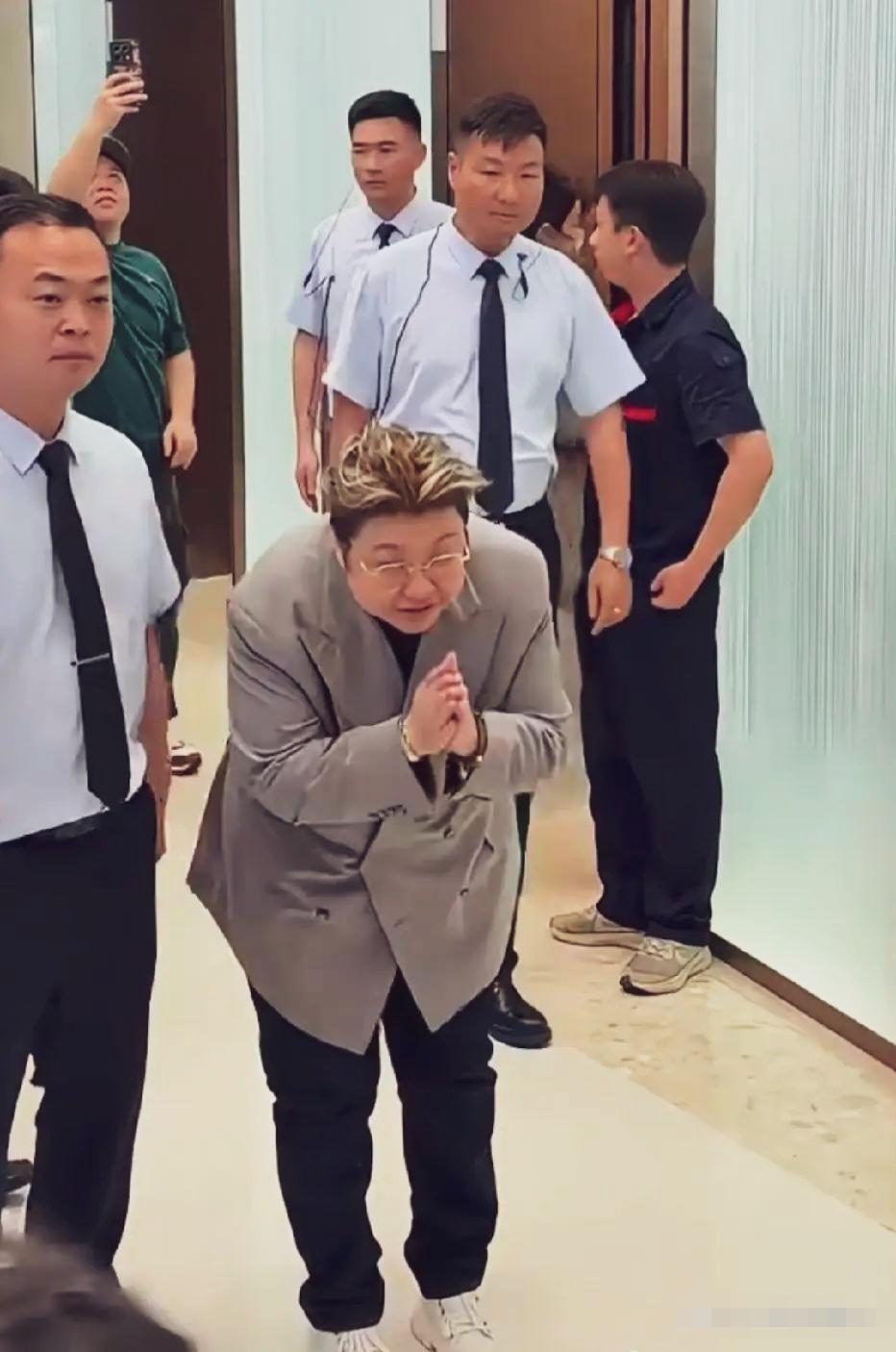 韩红老师线下活动的招牌动作娴熟利索，工作人员前呼后拥，她双手合十鞠躬作揖，然后匆