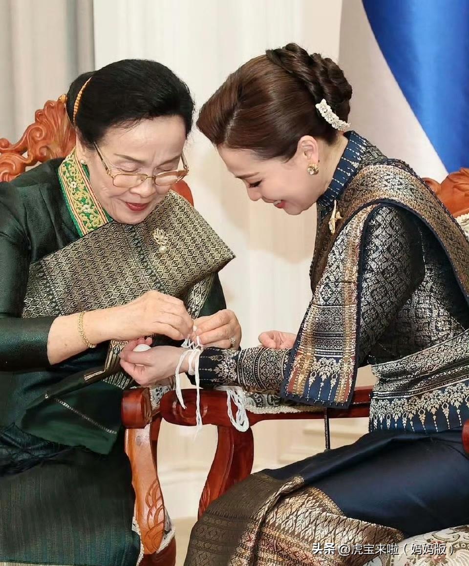 国王夫妇出席老挝主席举办的传统国宴！主席夫人在为苏提达王后拉白线（老挝祈福方式）
