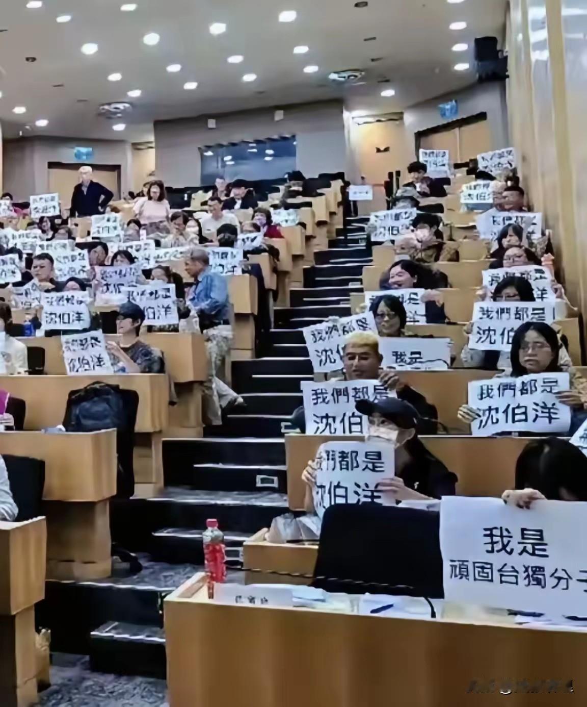 台湾一所大学，一群人举着“我们都是沈伯洋”“我是顽固台独分子”的标语，上演了一出