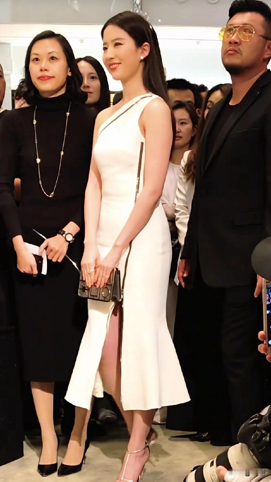 刘亦菲，她身着一袭白色单肩鱼尾裙，裙身贴合，裙摆呈鱼尾状自然垂落，搭配银色细带高