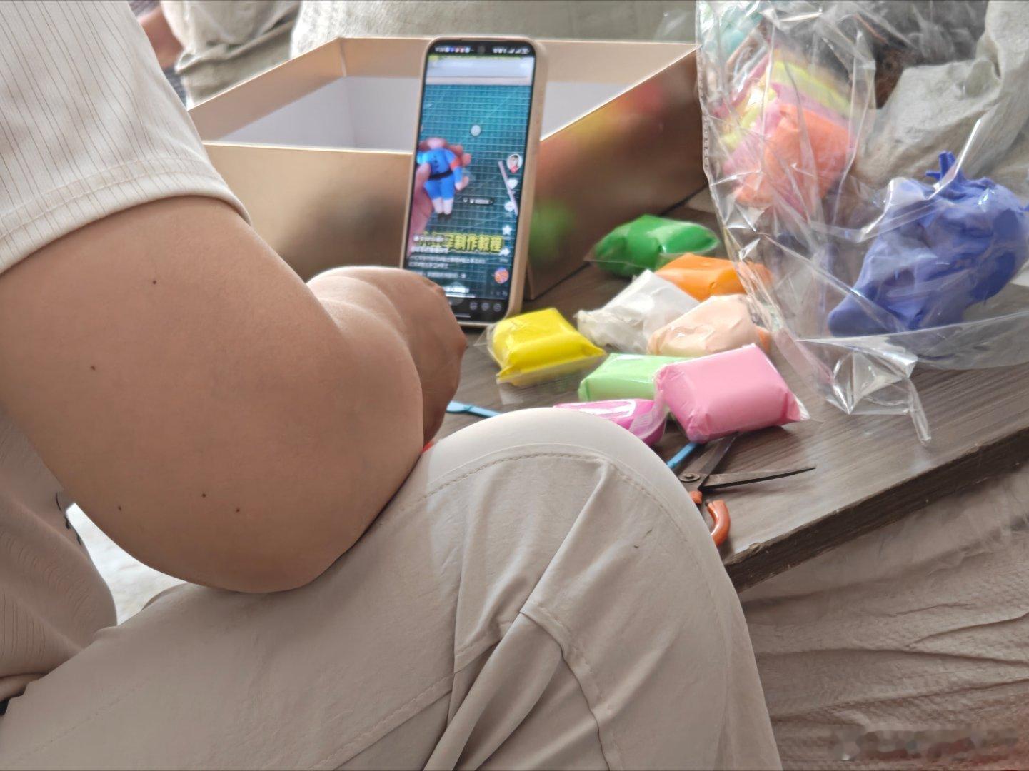 vivo 一位妈妈在帮孩子做手工，对着手机教程一步一步制作生怕出错，这态度太认真