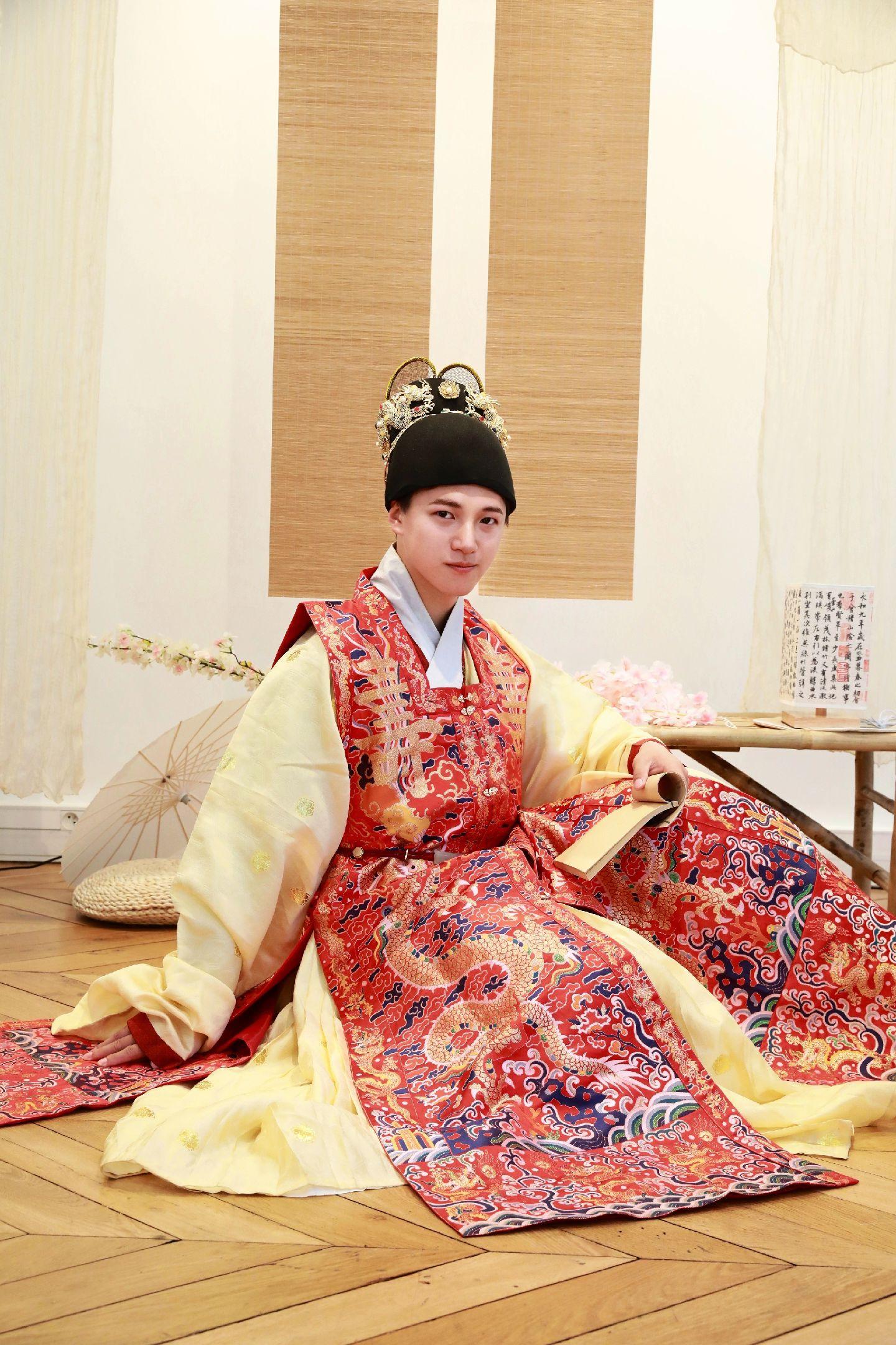 巴黎-将万历宫廷审美带到法兰西Shein.在巴黎 工作室参加活动抱到了可爱的阿尼亚
明澈衣柜：万历款二龙火焰宝珠翼善冠
来料的金花贴里，搭配 万历朝罩甲。
宫廷中使用的罩甲大多会饰以织金龙纹云肩及膝襕等纹样，如这件衣服的文物原型p2,3美国旧金山亚洲艺术博物馆藏万历二十三年罩甲。
纹样追求华丽与吉祥，除有华丽的龙纹还有寿及卍字样，衣服底部缘边也是大量小龙纹样,山海纹样，以及大量彩色云纹。自定陵文物看，万历时宫廷服饰吉祥字样大量出现在服饰上，现在把暴富，好运，大吉图案穿在身上感觉也和这