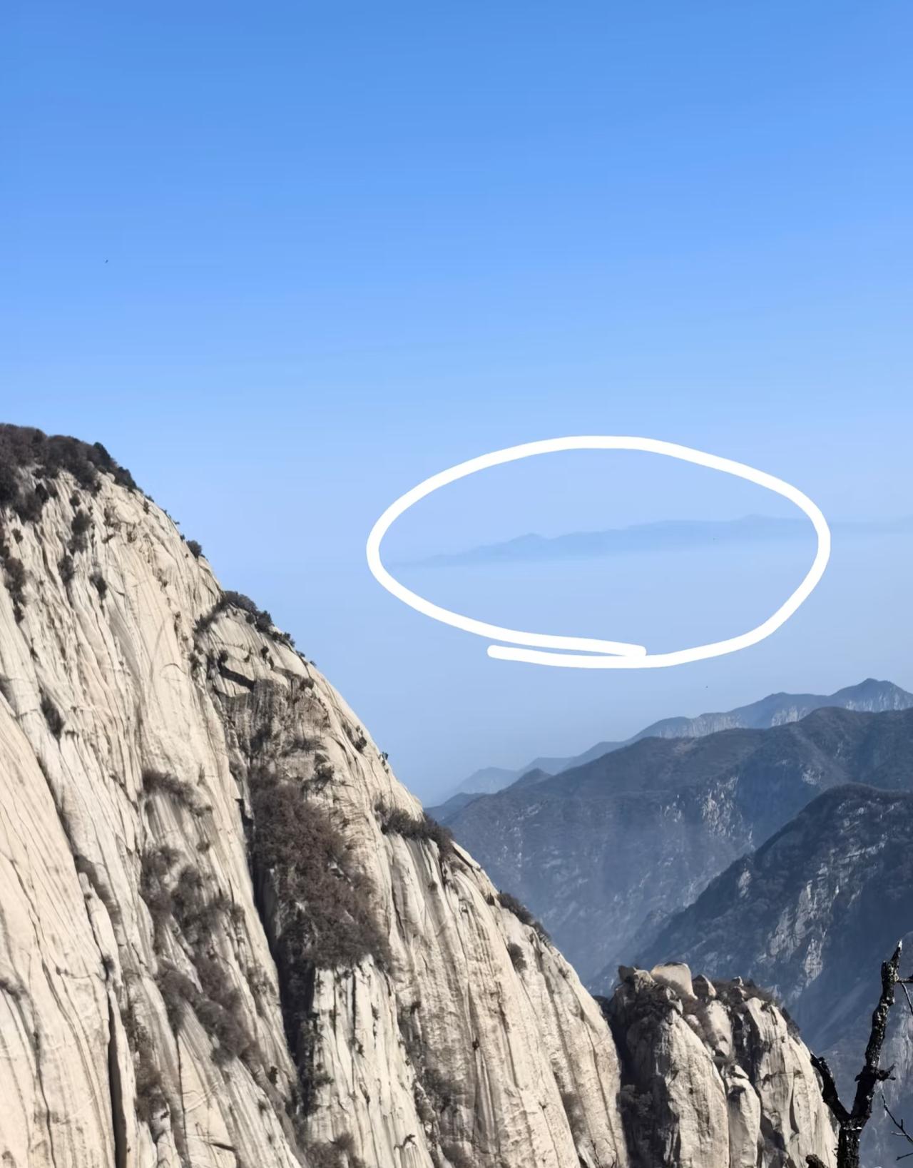 圈中的这座山叫什么？
这是去年和朋友爬华山的时候，
在华山北峰拍的图。
透过云层