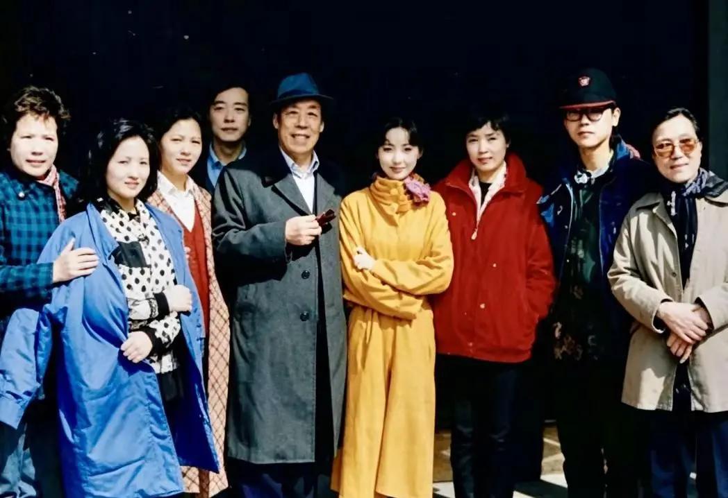 这张照片是87版《红楼梦》里演员和主创等的一张合照。
站中间的两位，穿黄色长风衣