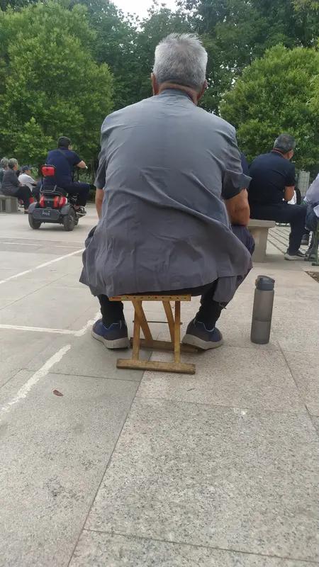 看到网友拍下的这幕真的挺暖心。父女俩没买到坐票，只能带着小马扎在高铁角落凑合。但