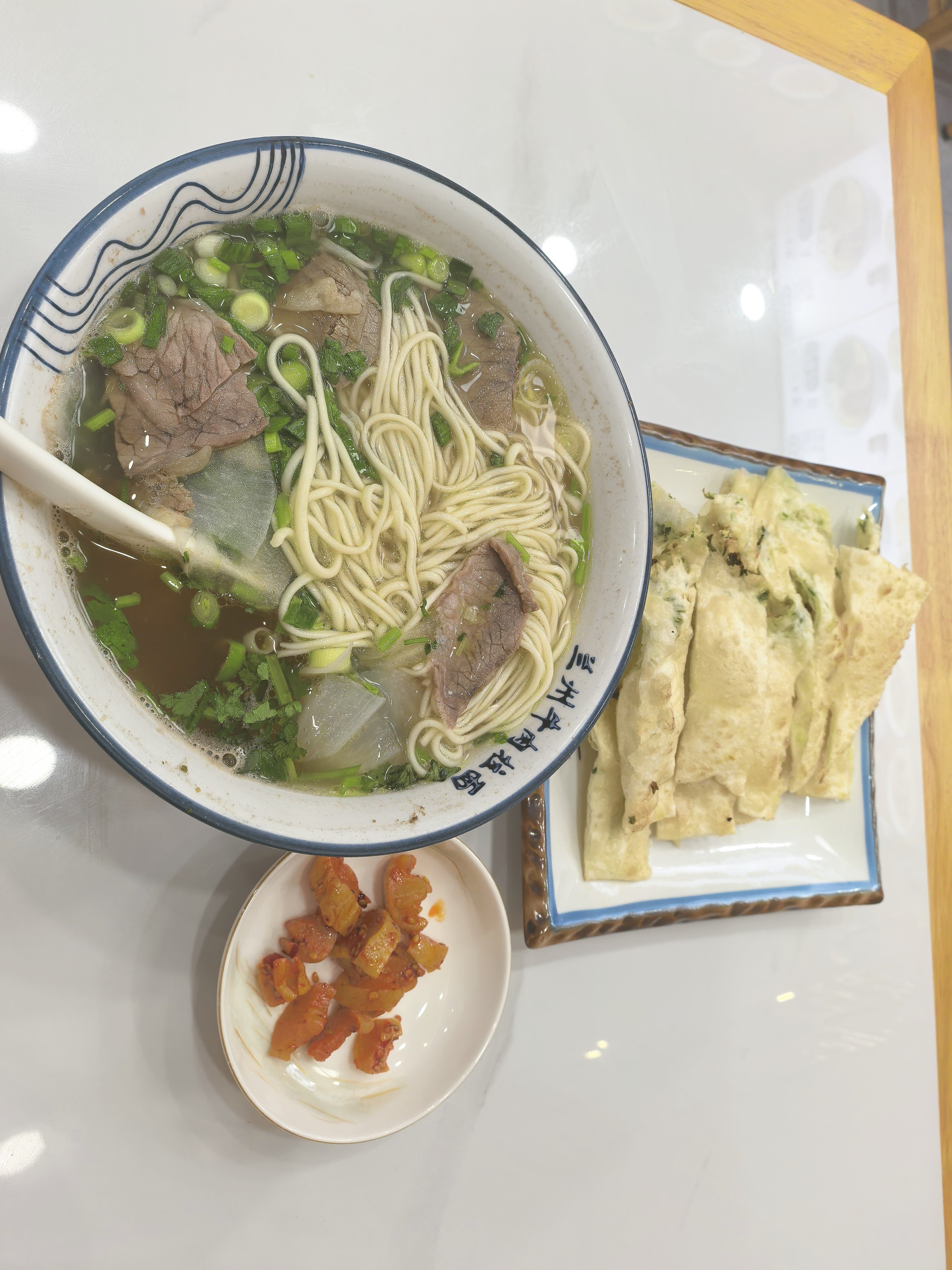 快乐是碳水给的✨一碗热气腾腾的牛肉拉面，配上酥脆葱油饼，再来一小碟爽口咸菜。清汤