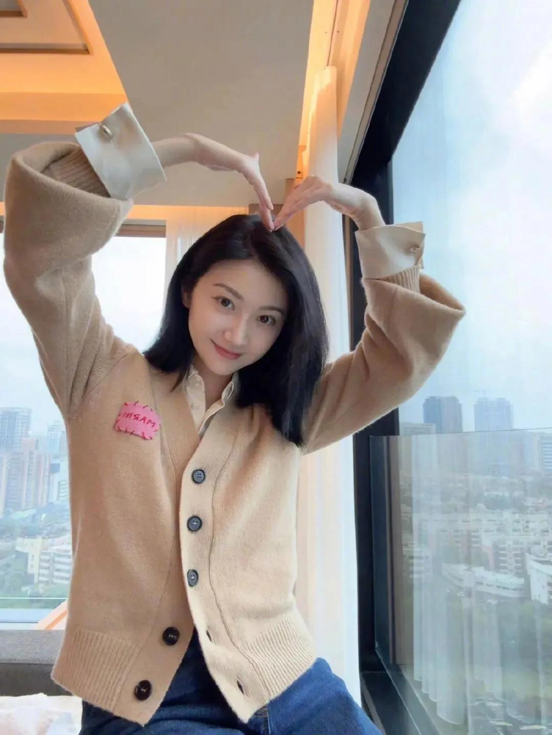 景甜晒美照向11月问好， 穿着驼色羊毛衫比心的样子可可爱爱， 厚厚的发量让网友羡
