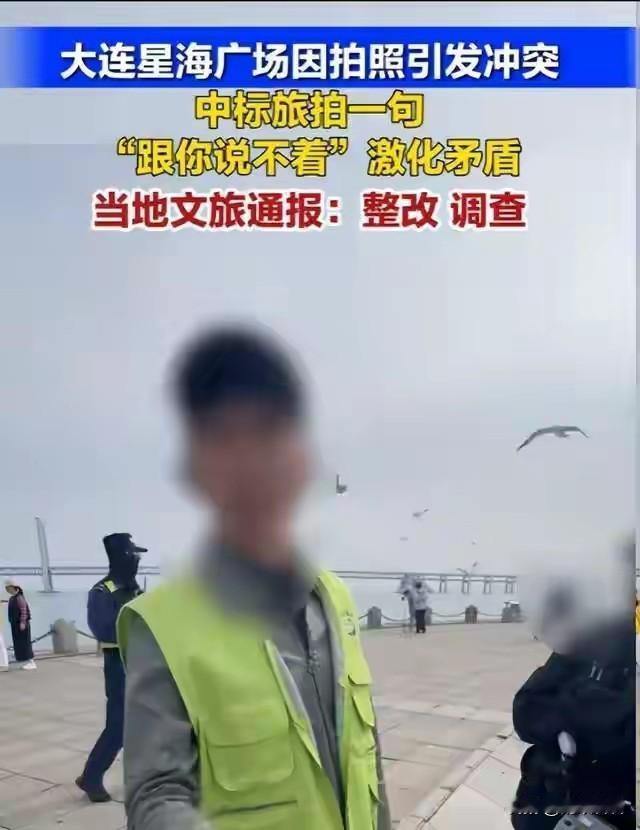 大连星海湾广场一名穿着印有星海嘉恒摄影黄马甲的人员。阻挡游客拍照。并声称这片区域