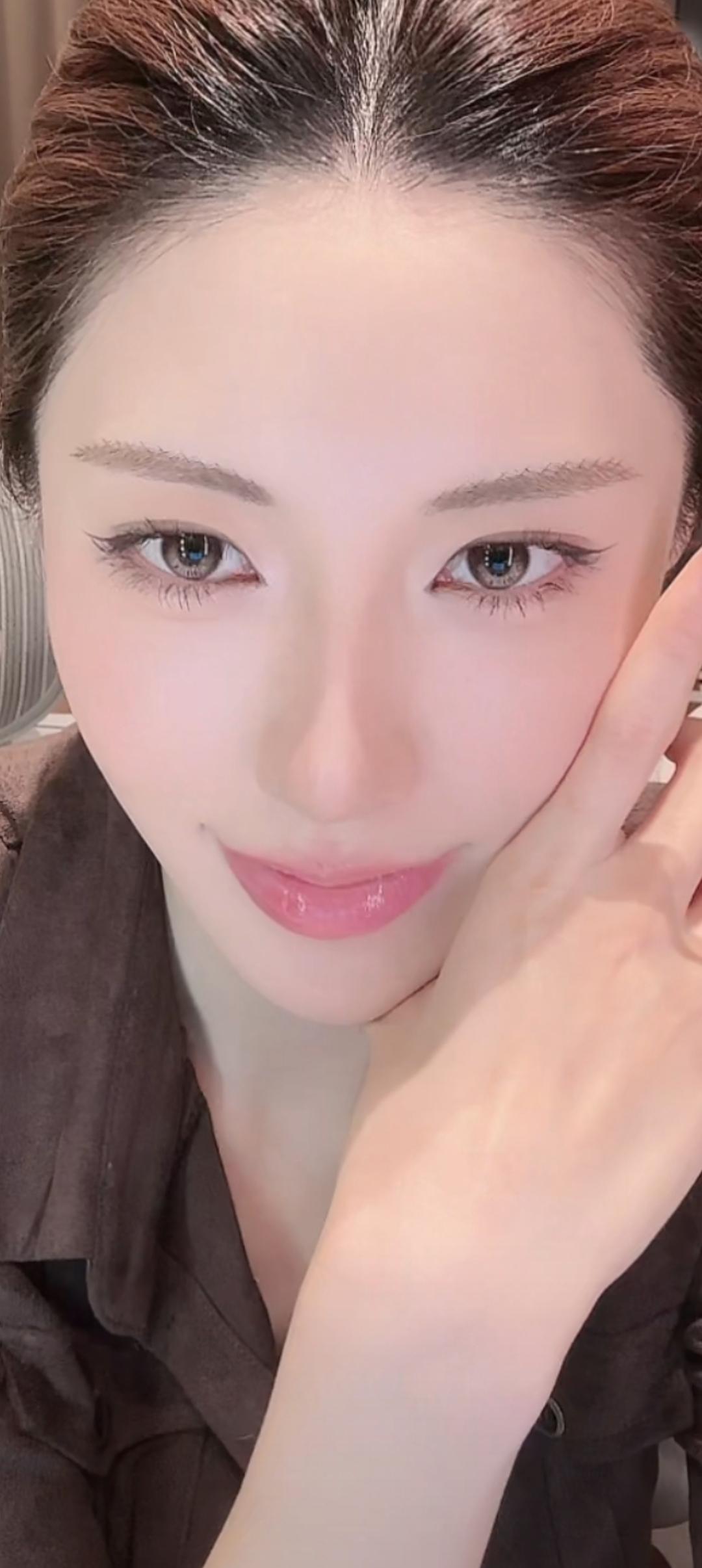 这位美女在微笑，手托着脸。