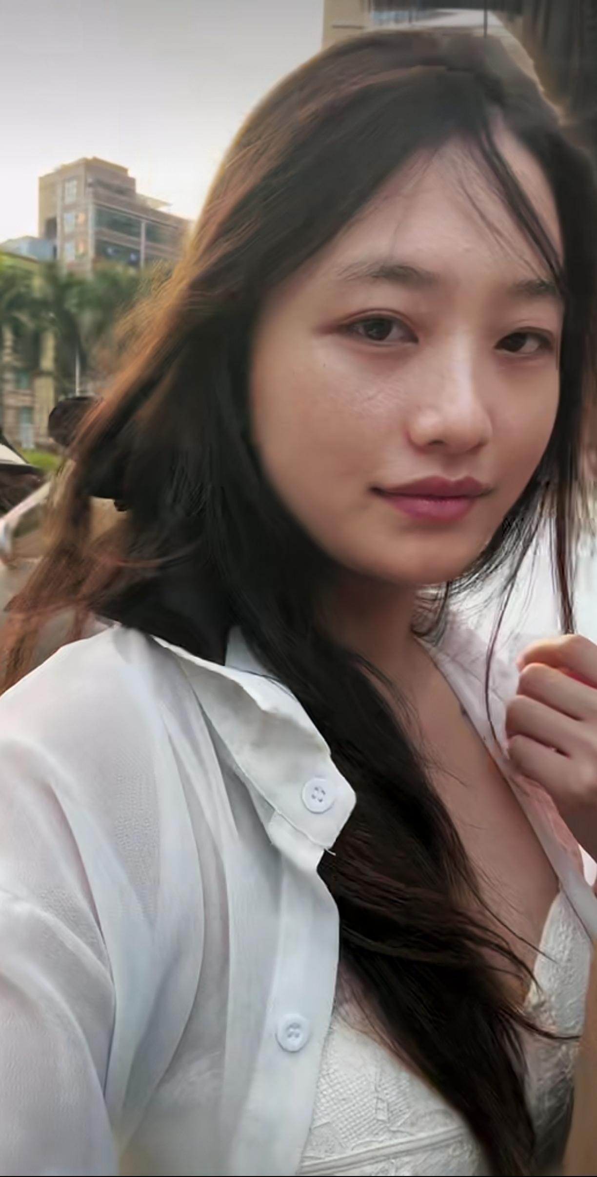漂亮女孩坐电动车后面拍照。