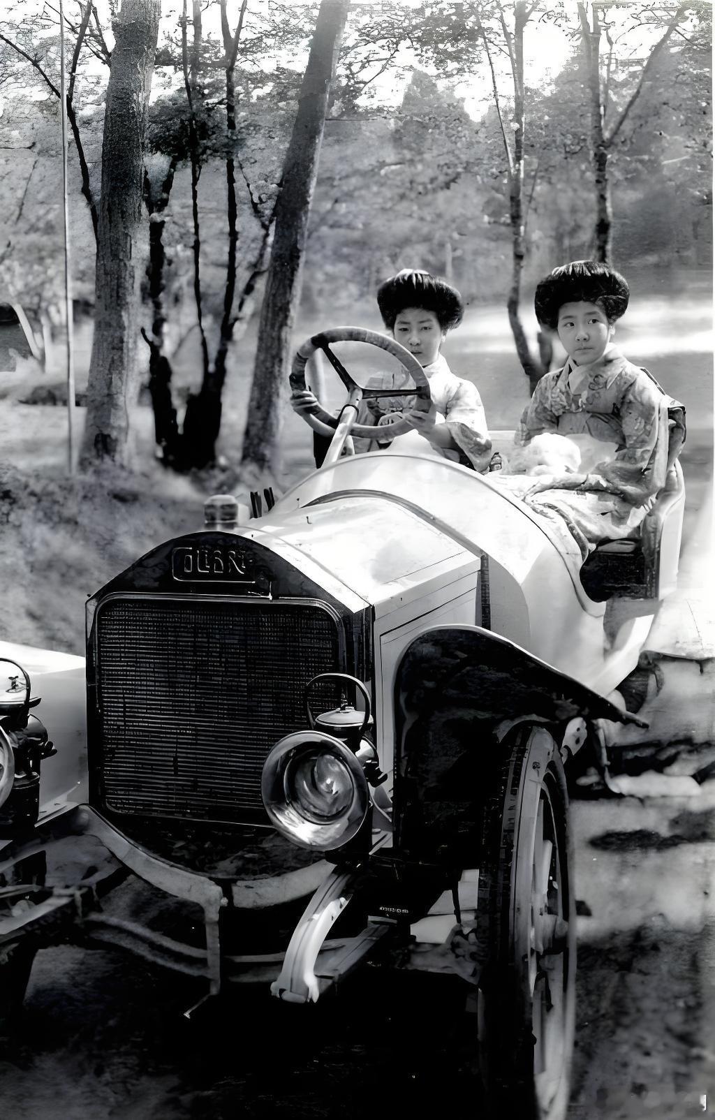 1912年，东京。日比谷公园南侧，两名艺妓开着一辆汽车。她们穿和服，梳“耸云髻”