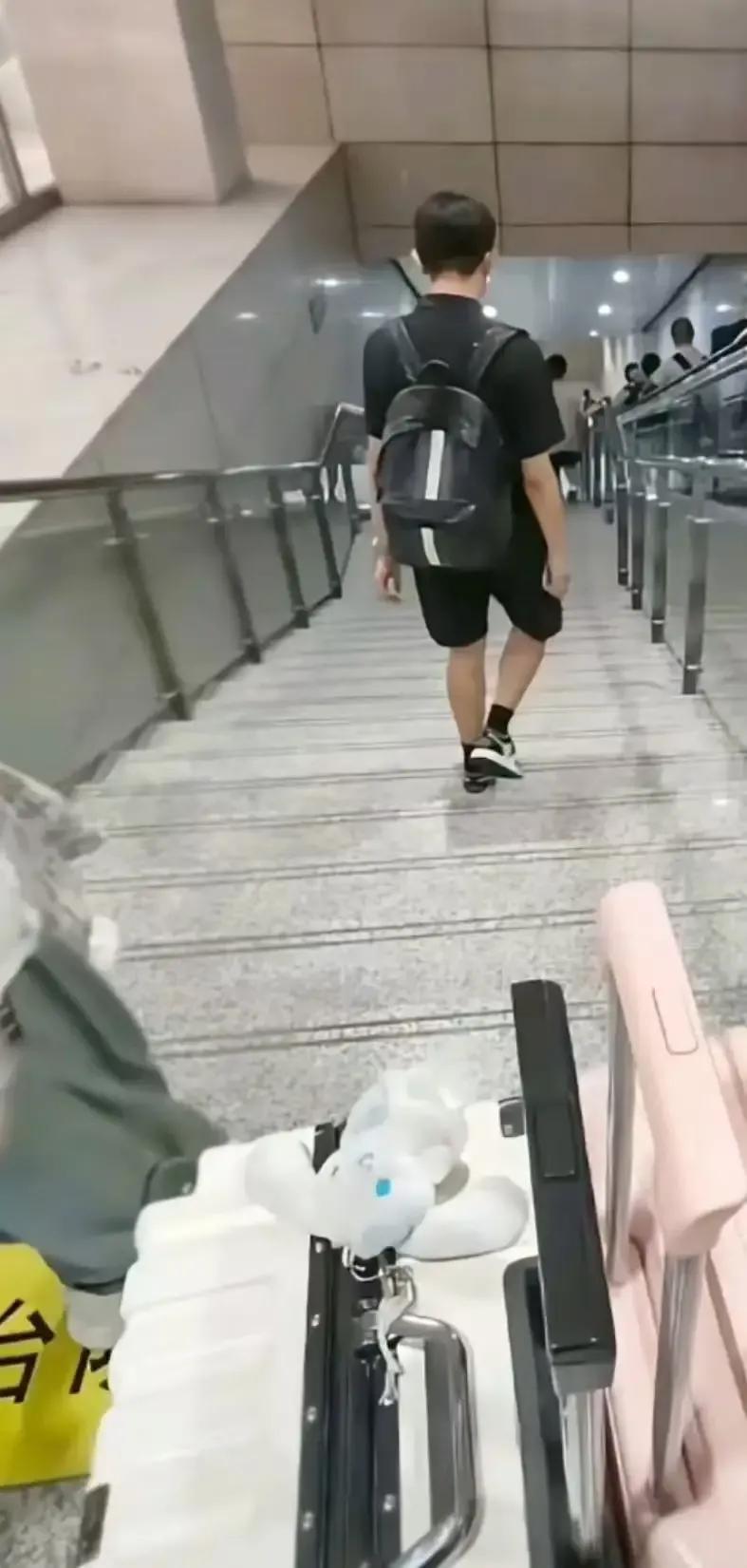 女生独自拖着超重行李箱下楼梯，身旁黑衣男全程无动于衷——她发视频怒斥“男的没品德