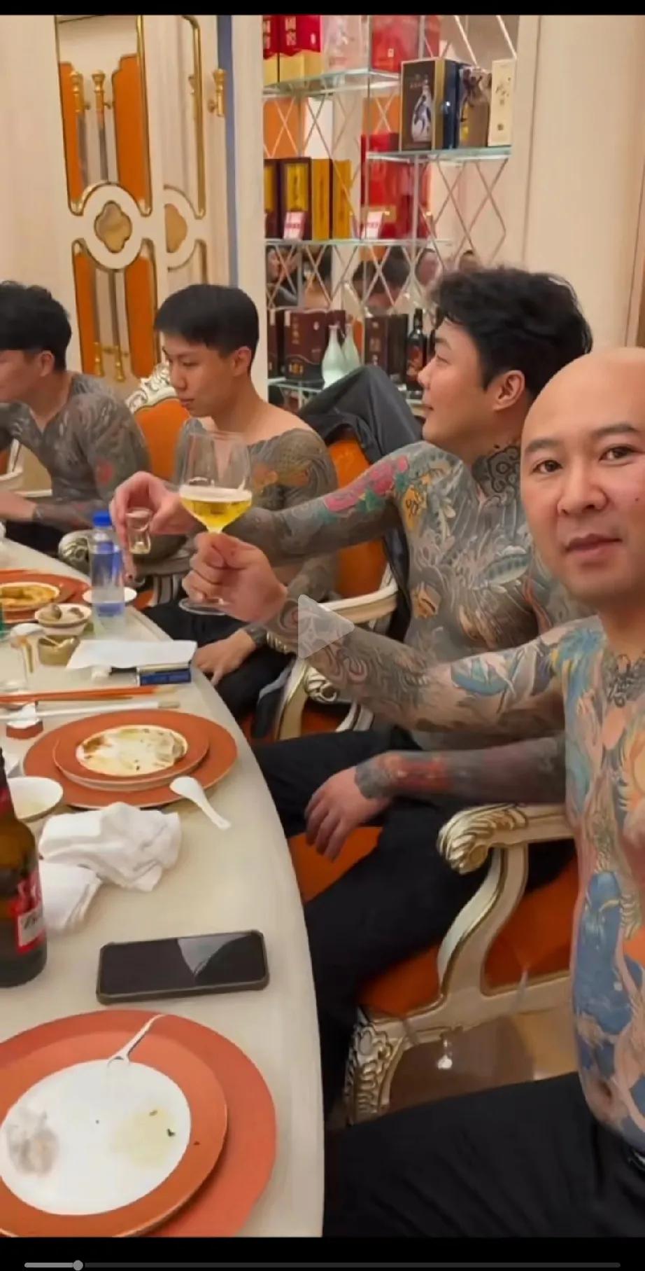 这些人的身上全是雕龙画凤，干啥的呢，吃个饭，为了展示纹身的美，上衣都不穿。
可能