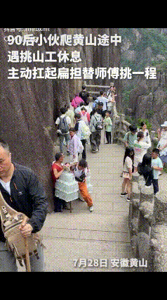 7月28日，安徽黄山，90后小伙在爬黄山的途中，看到一挑山工在短暂歇息，没想到他