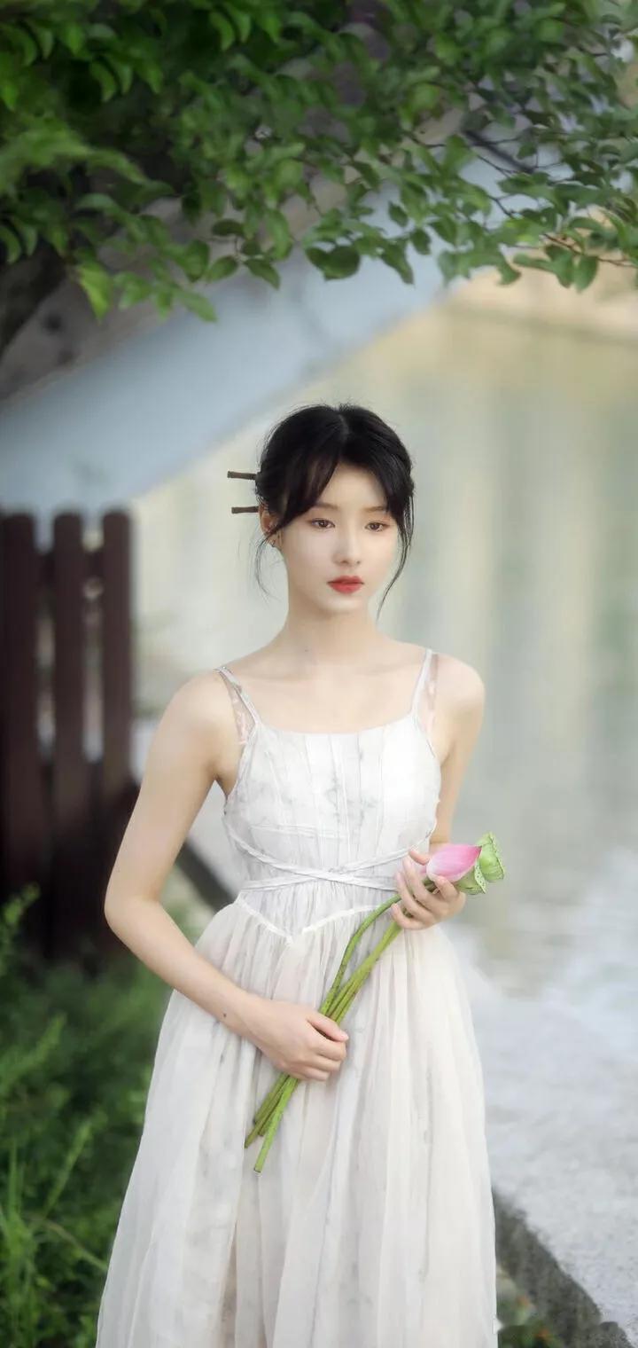 清新田园风，白裙少女手捧粉色花束。🌸👗🌿