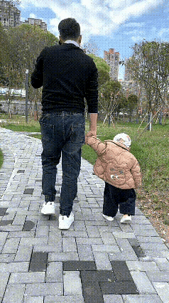 这样的爸爸称职吗？这么粗心大意！他带着小孩去逛公园，左手拿着手机打电话，右手拉着