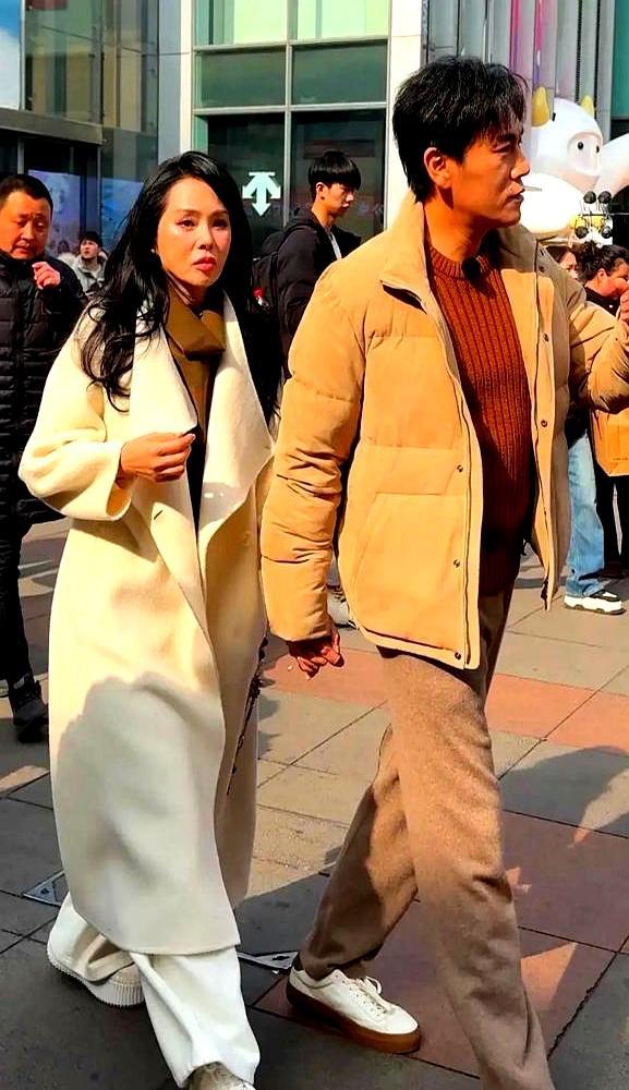 57岁伊能静新大衣吊牌都不剪，就跟秦昊十指紧扣压马路，沈阳街头这一幕，把我看傻了