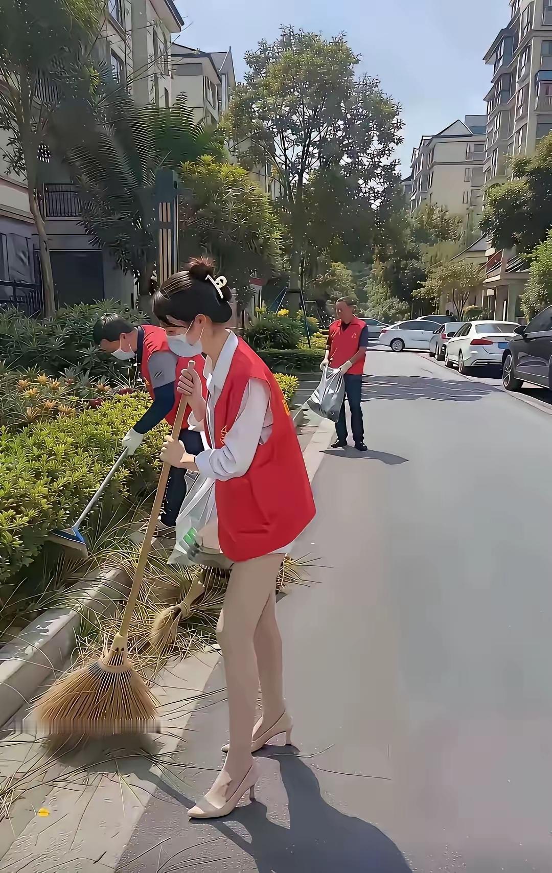 网友发的小区里早晨搞卫生的场面。如果不是摆拍，那个女的一定是平时很少参加劳动，看