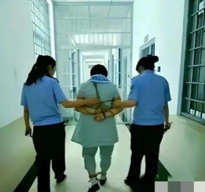 2014年，艾弘被押出辽宁本溪看守所，朝着刑场前进。这个普普通通的妇女，短发，其
