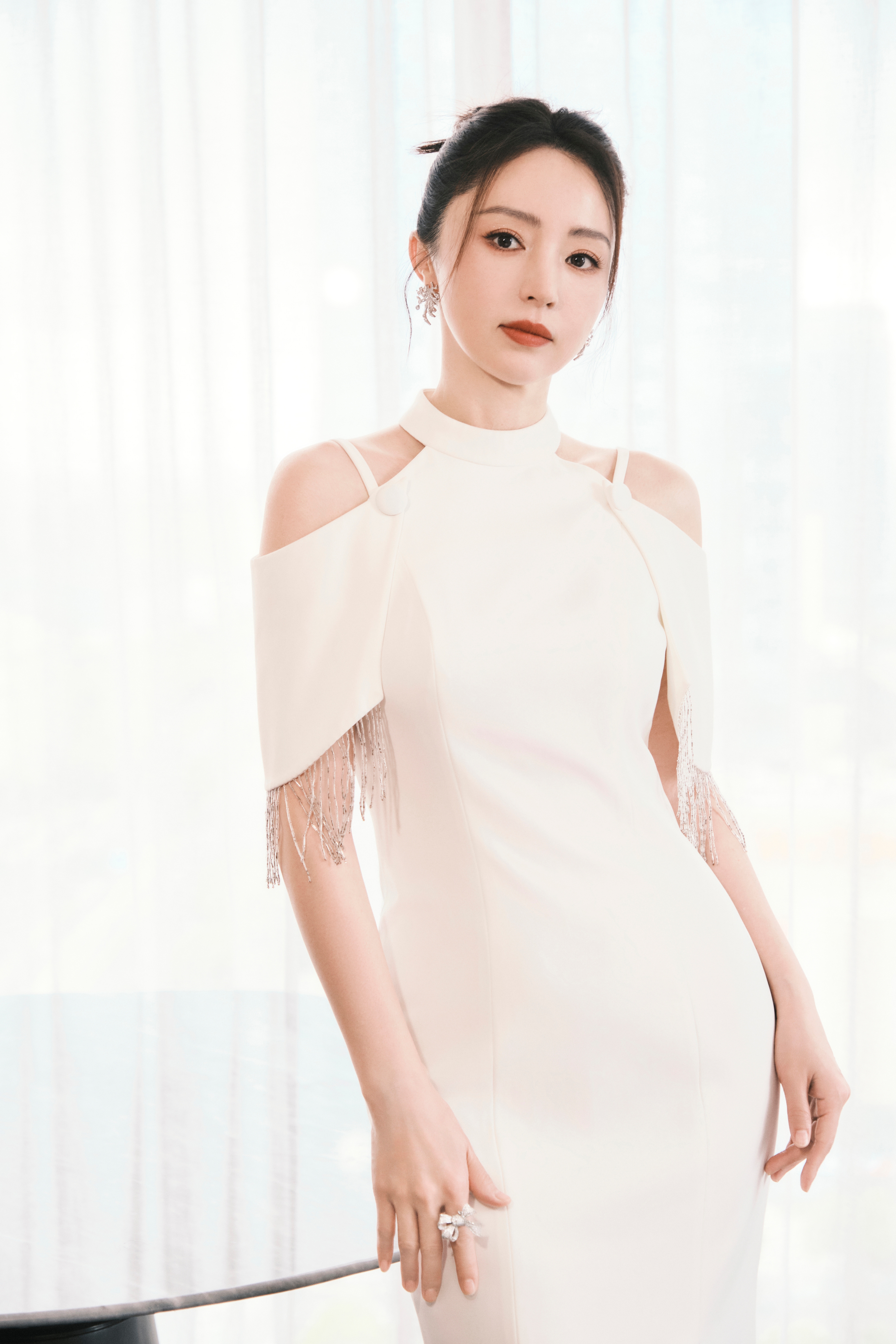 董璇  一袭净白露肩礼裙，流苏垂落雅致灵动。身姿娉婷温婉大方，笑容明媚亮眼动人。