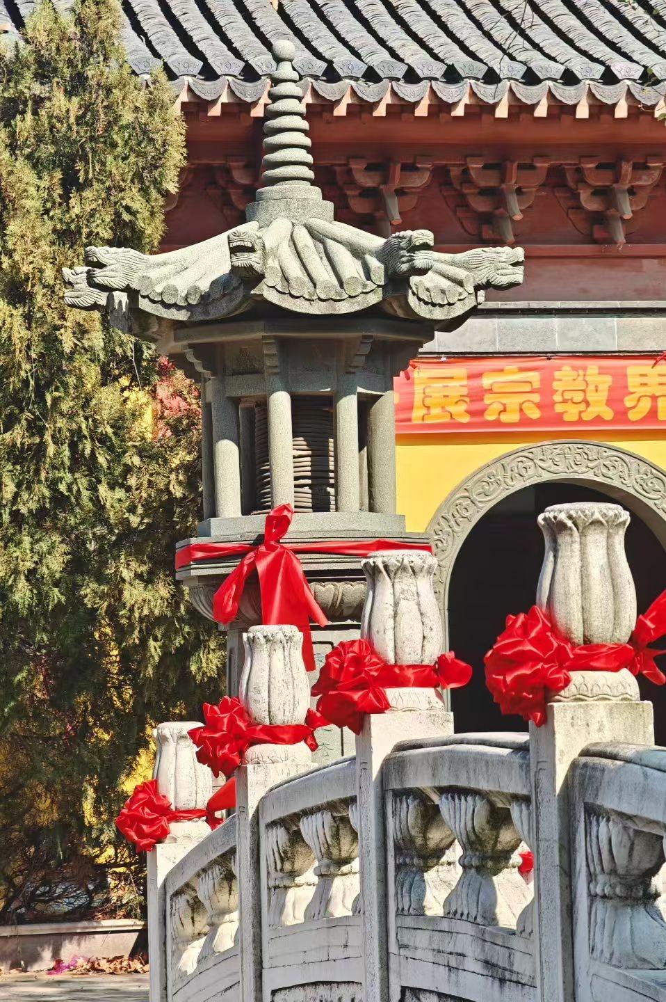 集卡领红包石栏系满红绸，古灯静立檐下。青灰与朱红相映，把岁月的厚重和人间的祈愿，