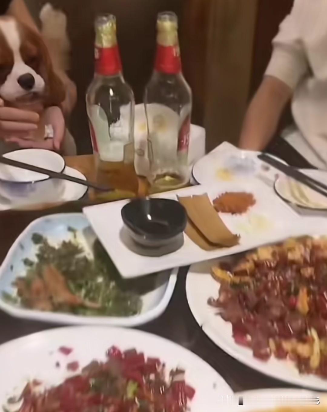 看这桌画面里，酒瓶子摆在桌面，狗狗凑在装了啤酒的杯子边舔，旁人看了心里都要犯嘀咕