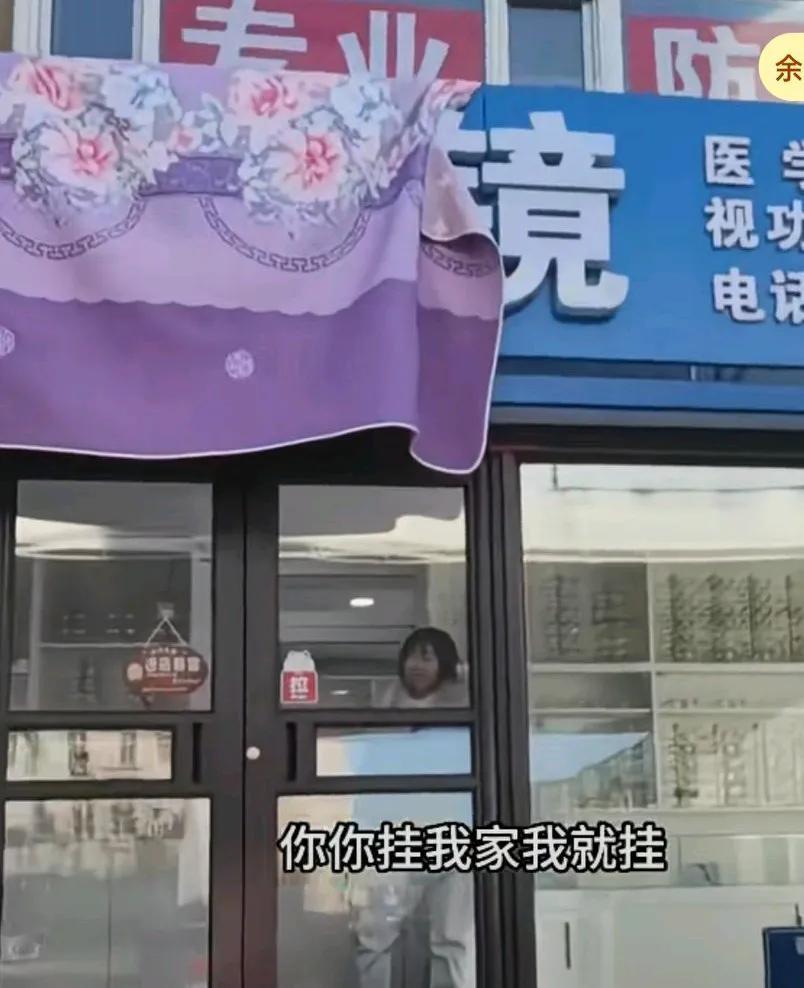 一楼的牌匾挡住了男子家采光，男子用床单将其盖住，
一楼人员出来说谁盖的男子说就是