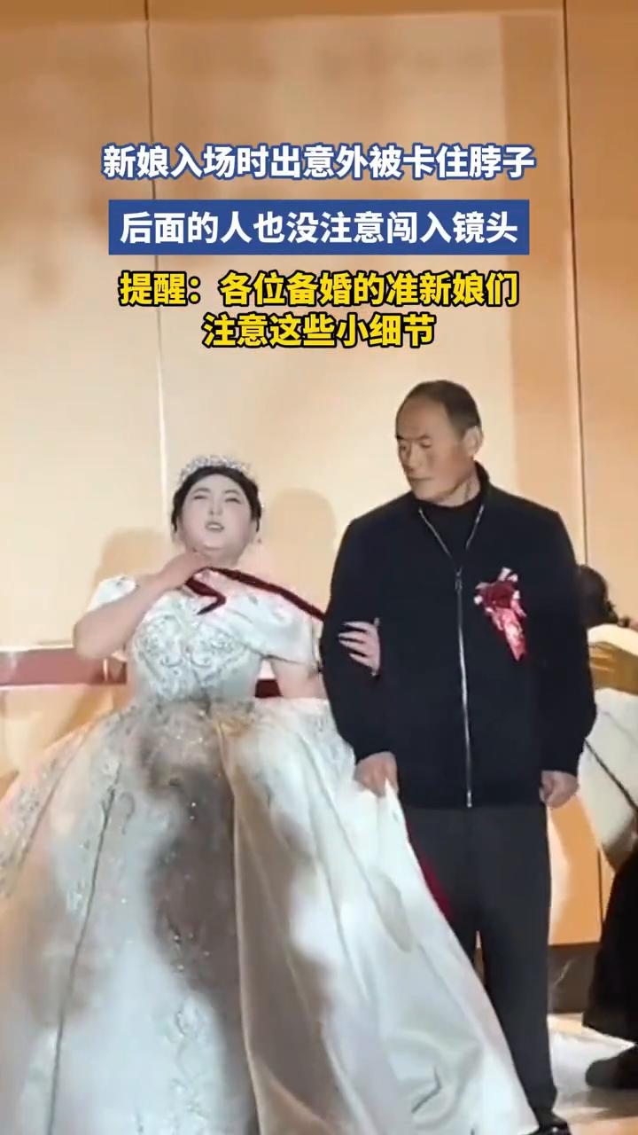 新娘入场时出意外被卡住脖子，后面的人也没注意闯入镜头。
提醒：各位备婚的准新娘们