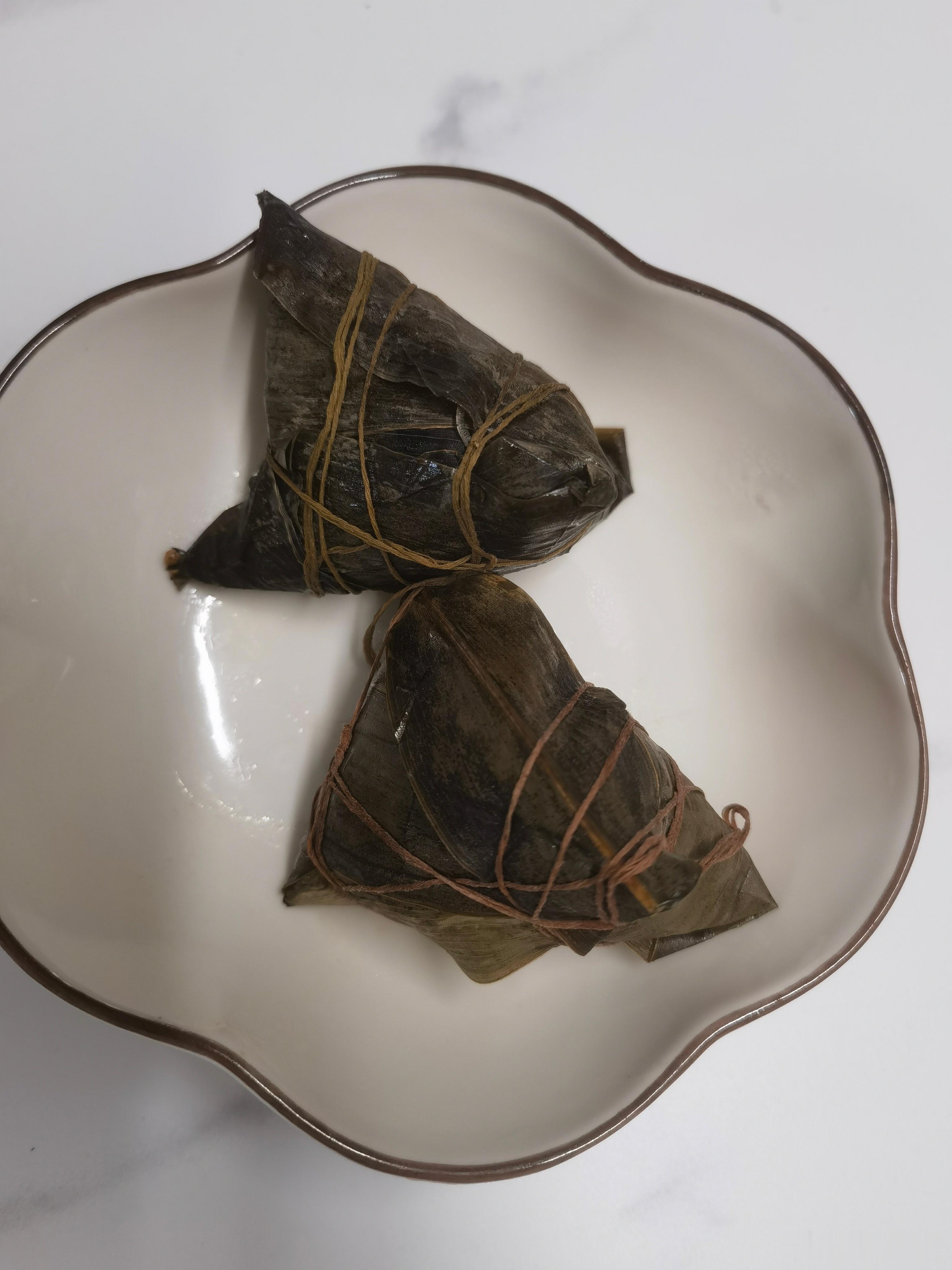 早上剥开热气腾腾的粽子，糯米香混着粽叶味扑鼻而来。咬一口软糯的蛋黄肉馅，突然觉得
