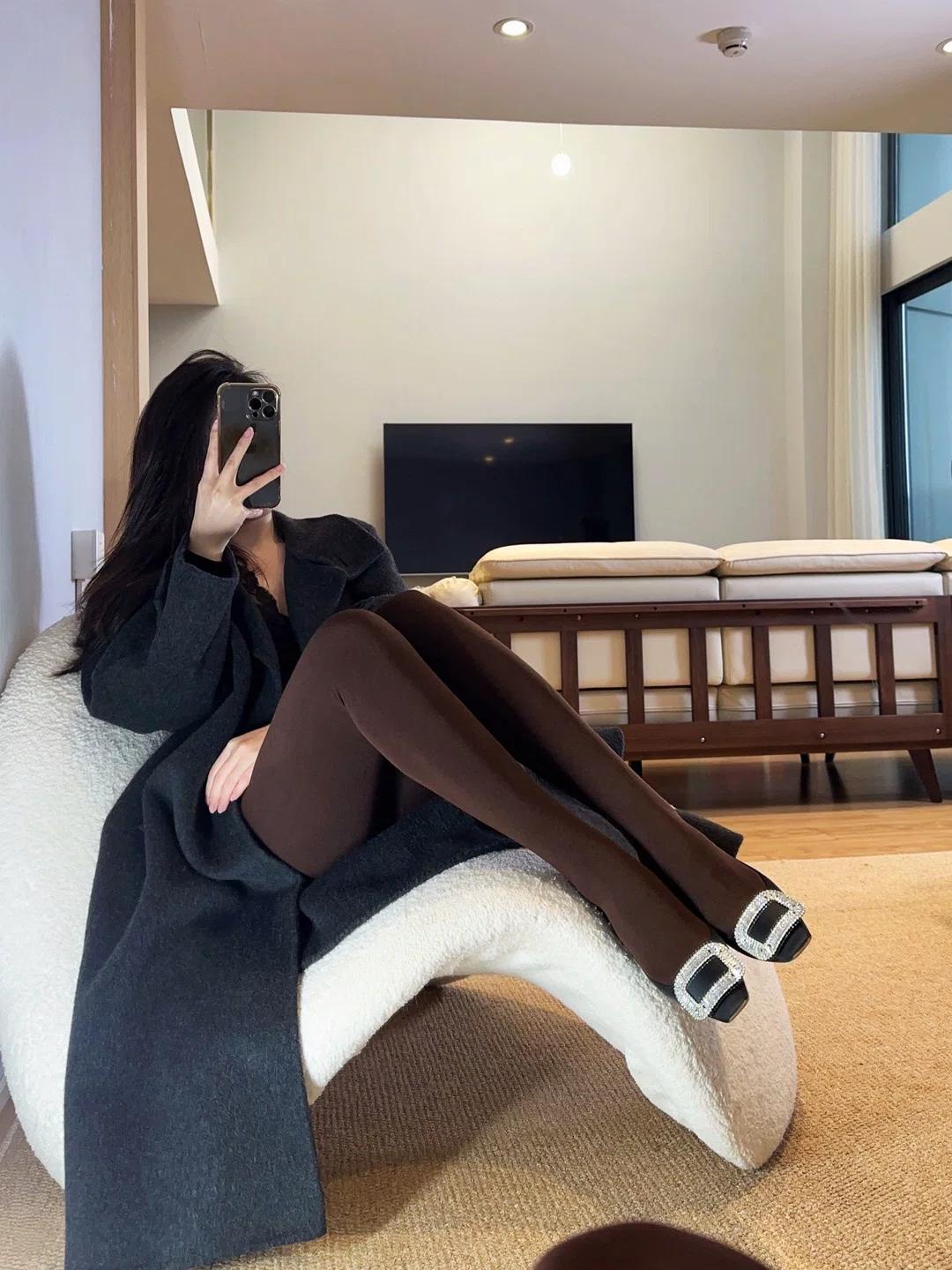 深棕连裤袜是今天的主角。
细腻的哑光面料顺着腿型延伸，把小腿线条修饰得流畅又温柔