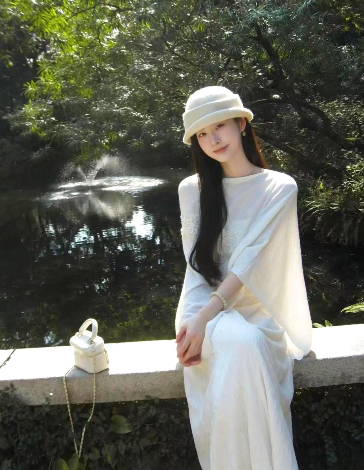 白衣如雪映清波，静坐湖畔意自闲。高雅气质美女