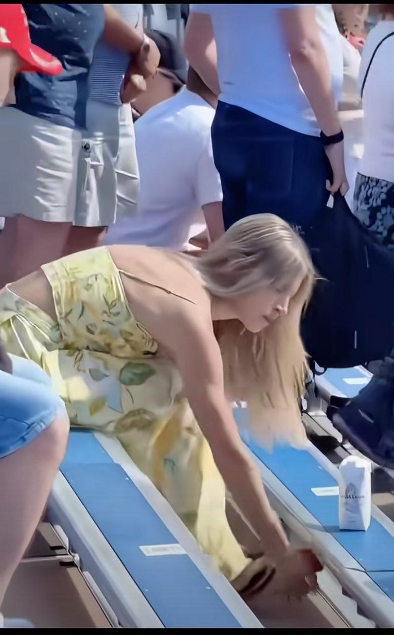 就是这个外国妹子，在大庭广众之下，轻松、从容的弯腰俯身，很熟练地从裙子里把自己的