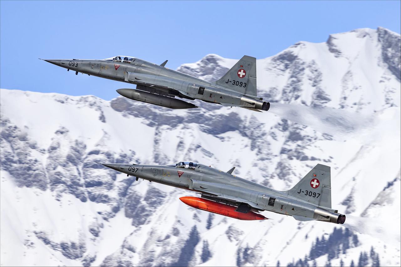 瑞士空军F5轻型战机在白雪皑皑的山谷间御风飞行。
