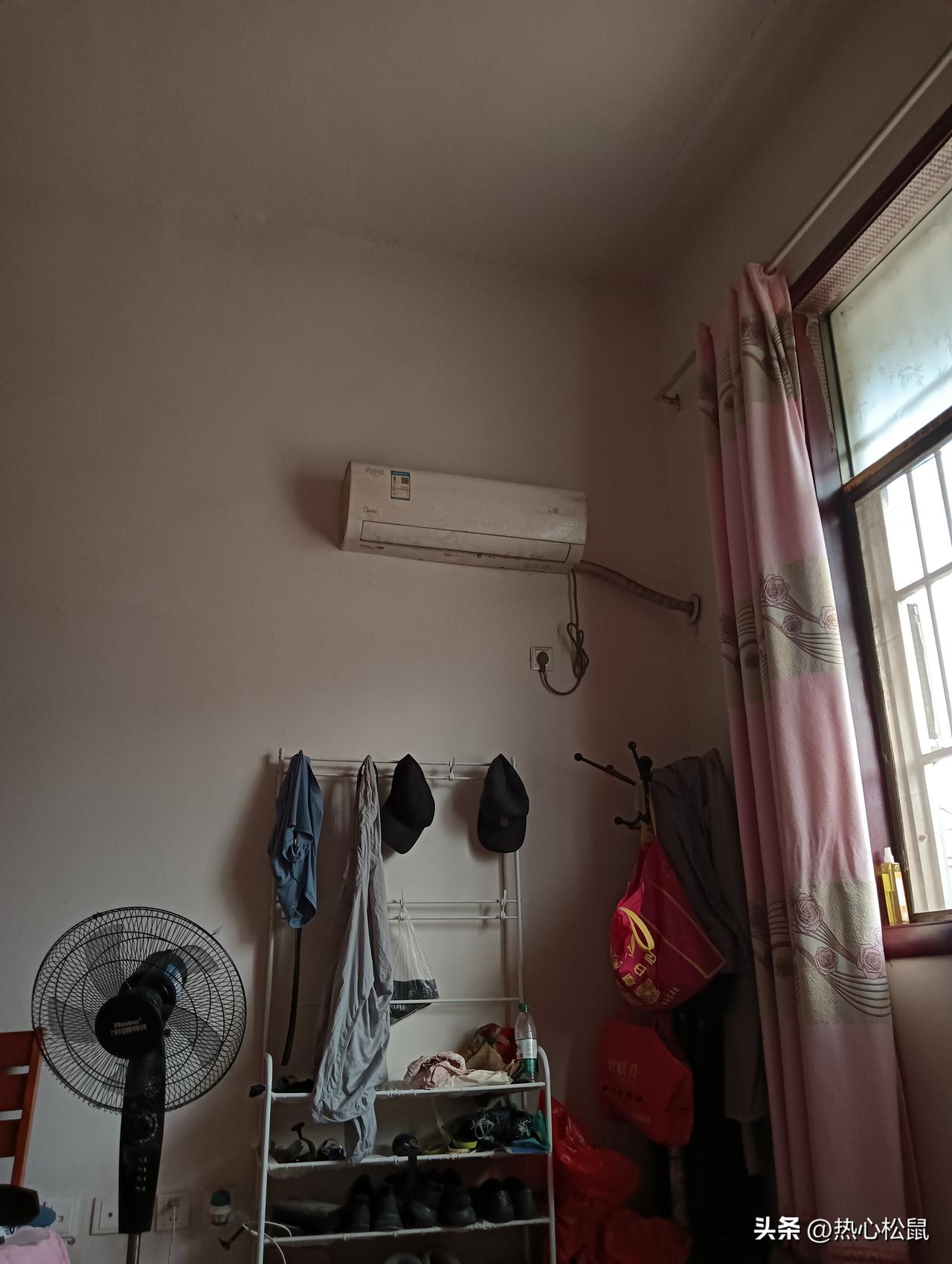 小房间里的空调、衣架和电风扇。